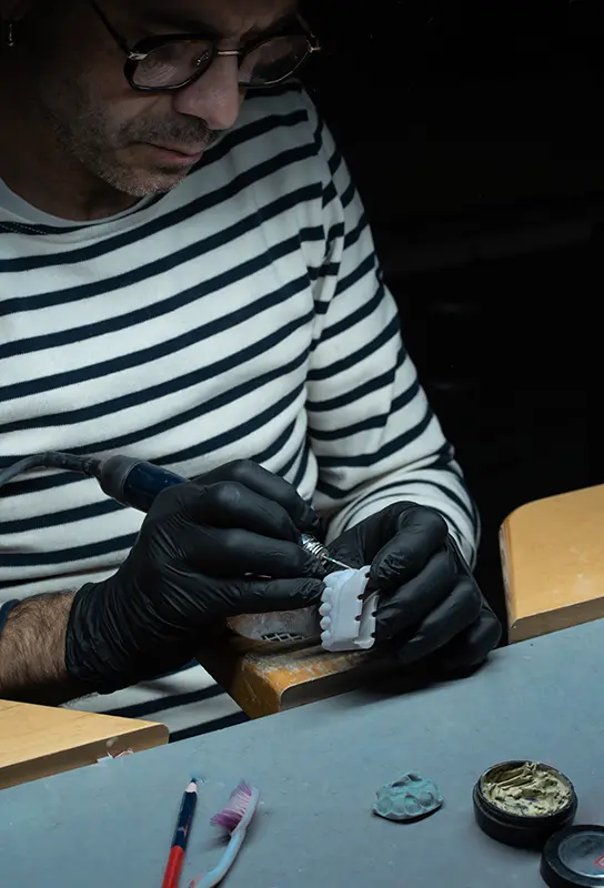 Laurent Grevaud, prothésiste dentaire et fondateur du Laboratoire 32, en plein travail de finition sur une prothèse.